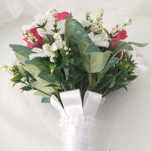 Buquê de flores com folhagens e laço branco.