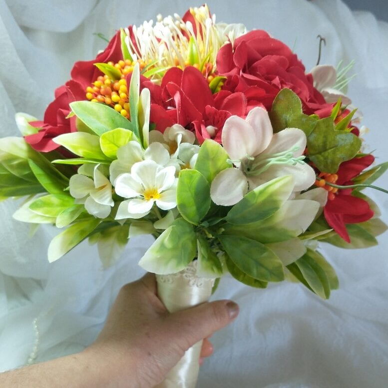 Buquê de flores em tons de vermelho, branco e verde, com veludo e folhagem, ideal para casamentos.