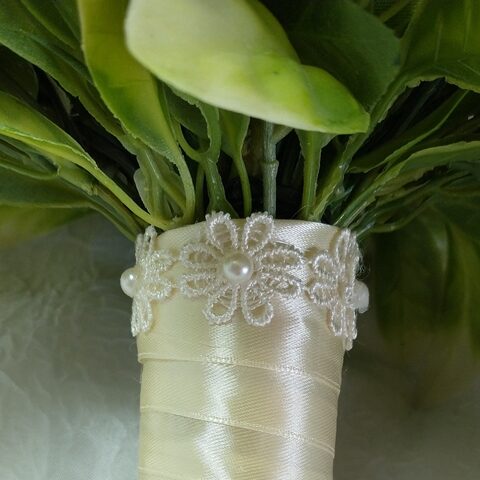Buquê de casamento com fita decorativa e detalhes de pérola.