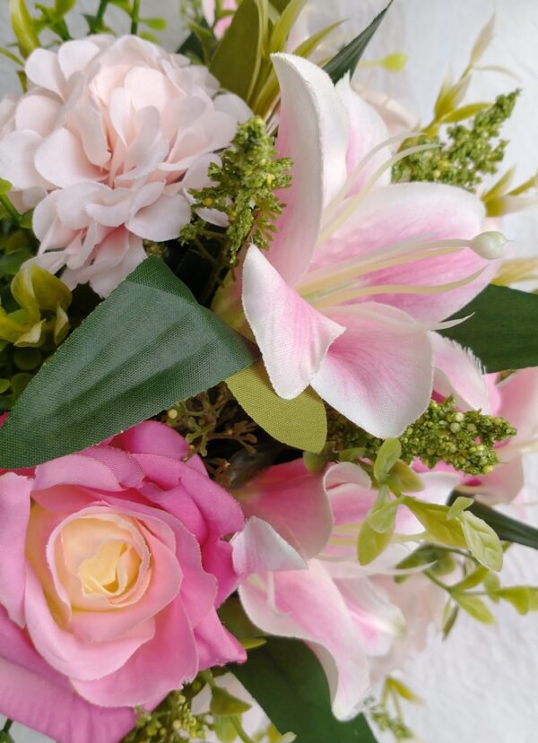 Bouquet de flores artificiais com rosas e lírios em tons de rosa e branco.