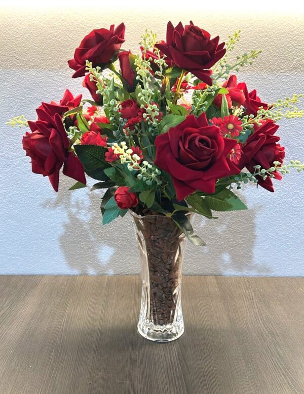 Vaso com arranjo de rosas vermelhas e flores decorativas brancas e vermelhas.