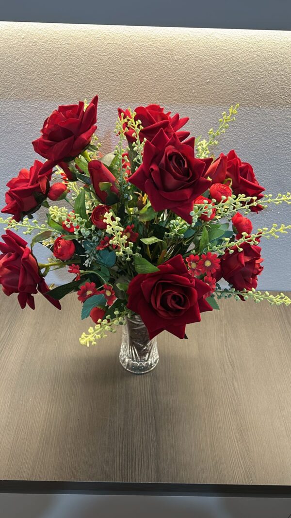 Ramo de rosas vermelhas em vaso de vidro.