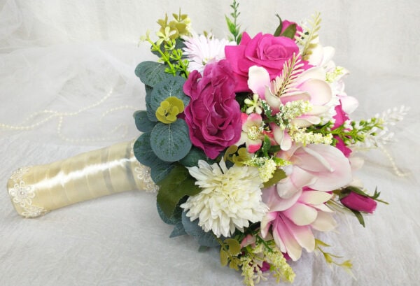 Bouquet de casamento com rosas pink e detalhes brancos, decorado com folhagens verdes.