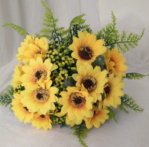 Flor rosa amarela com folhas verdes e buquê de flores decorativas.