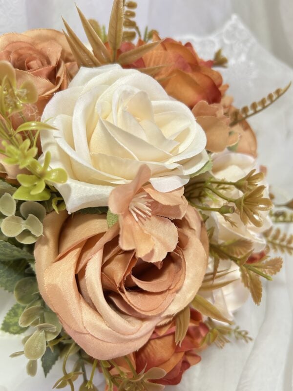 Ramo de flores artificiais com rosas em branco e tons de pêssego, decorativo e elegante.