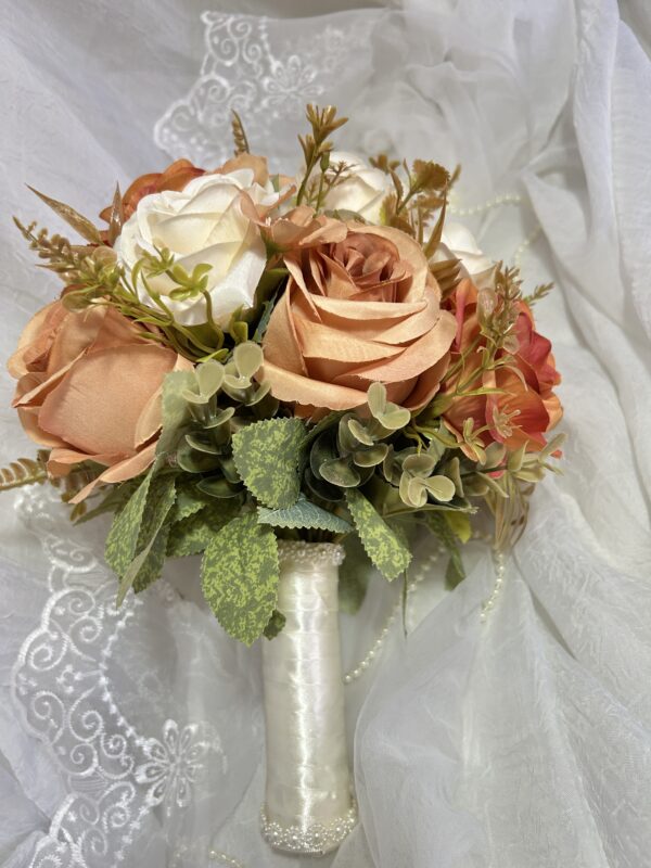 Ramo de rosas em tons de rosa claro, branco e peach com folhas verdes decorativas.