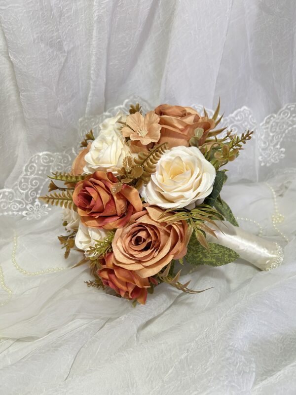 Buquê de flores em tons de bege, branco e cor de rosa, com rosas e folhagens artificiais.