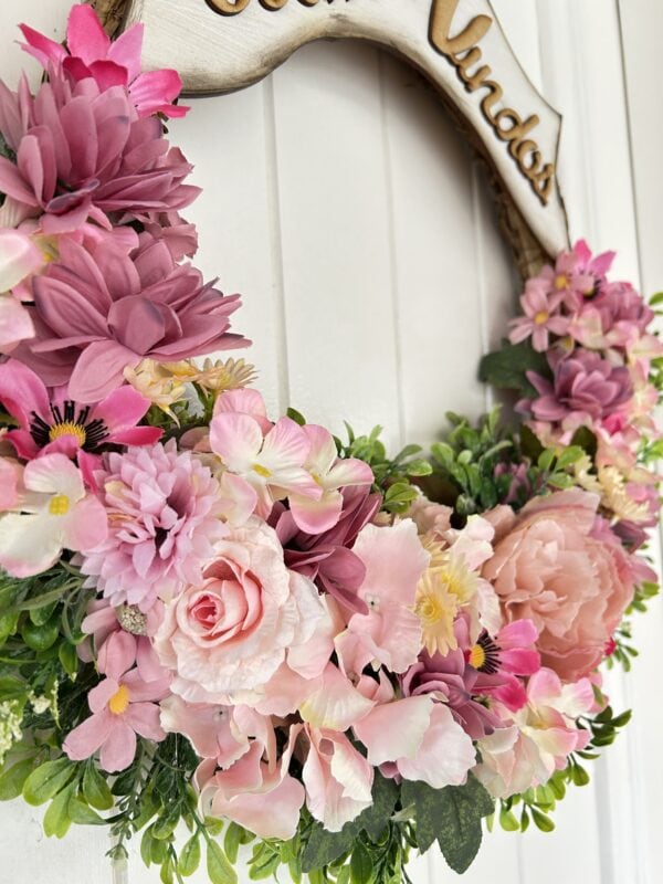 Flores delicadas em tons de rosa, incluindo rosas e flores de jardim, formando um belo arranjo floral decorativo.