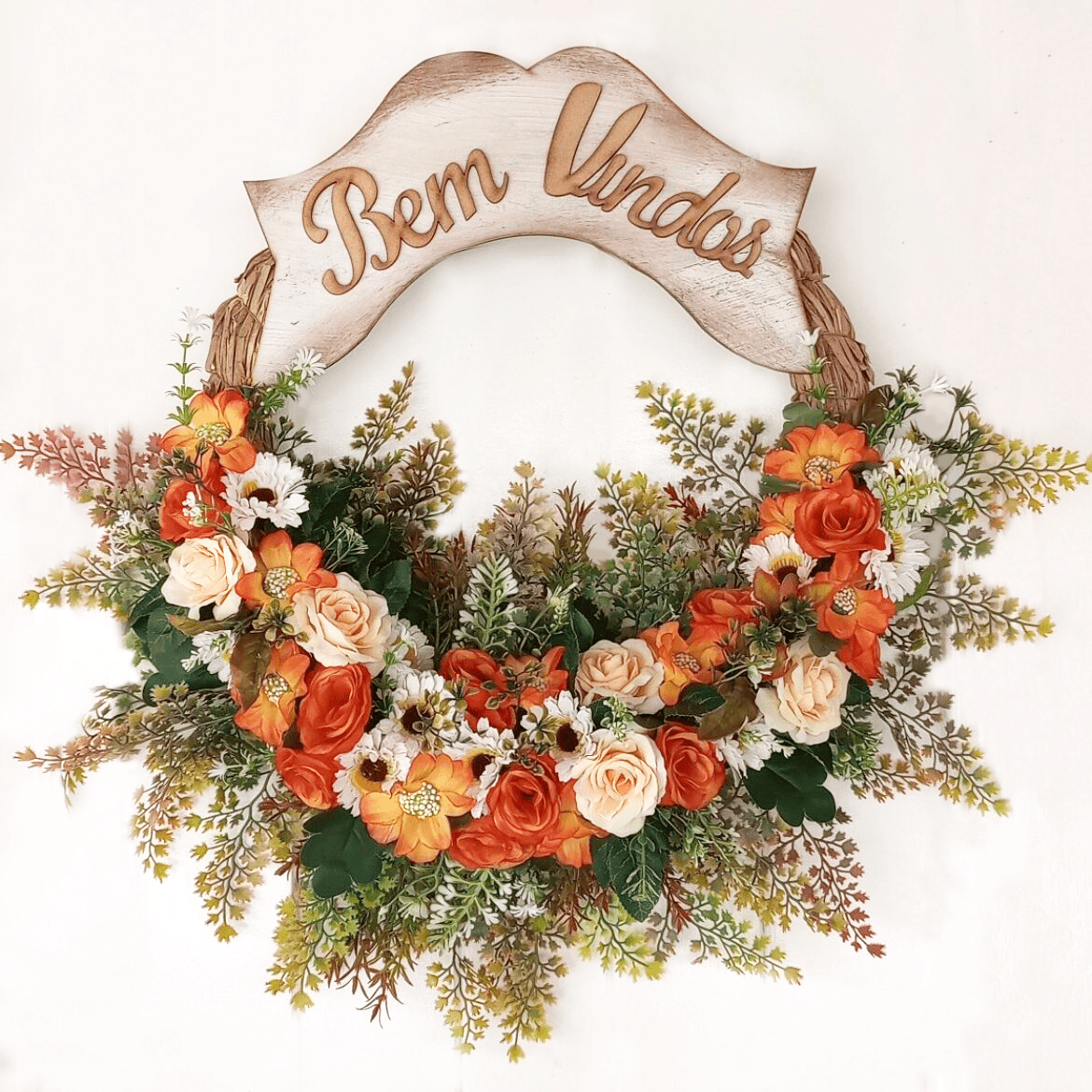 Buquê de flores artificiais com arranjo de plantas verdes.