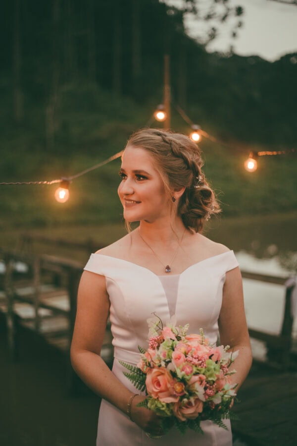Bouquet de casamento com flores rosas e verdes ao ar livre durante o pôr do sol.