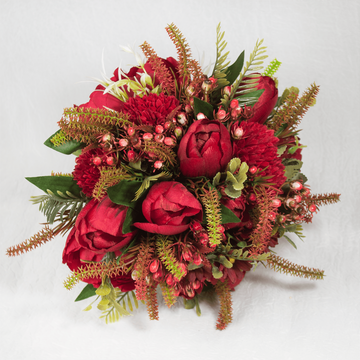 Ramo de flores vermelhas com folhas verdes e detalhes em rosa e branco.