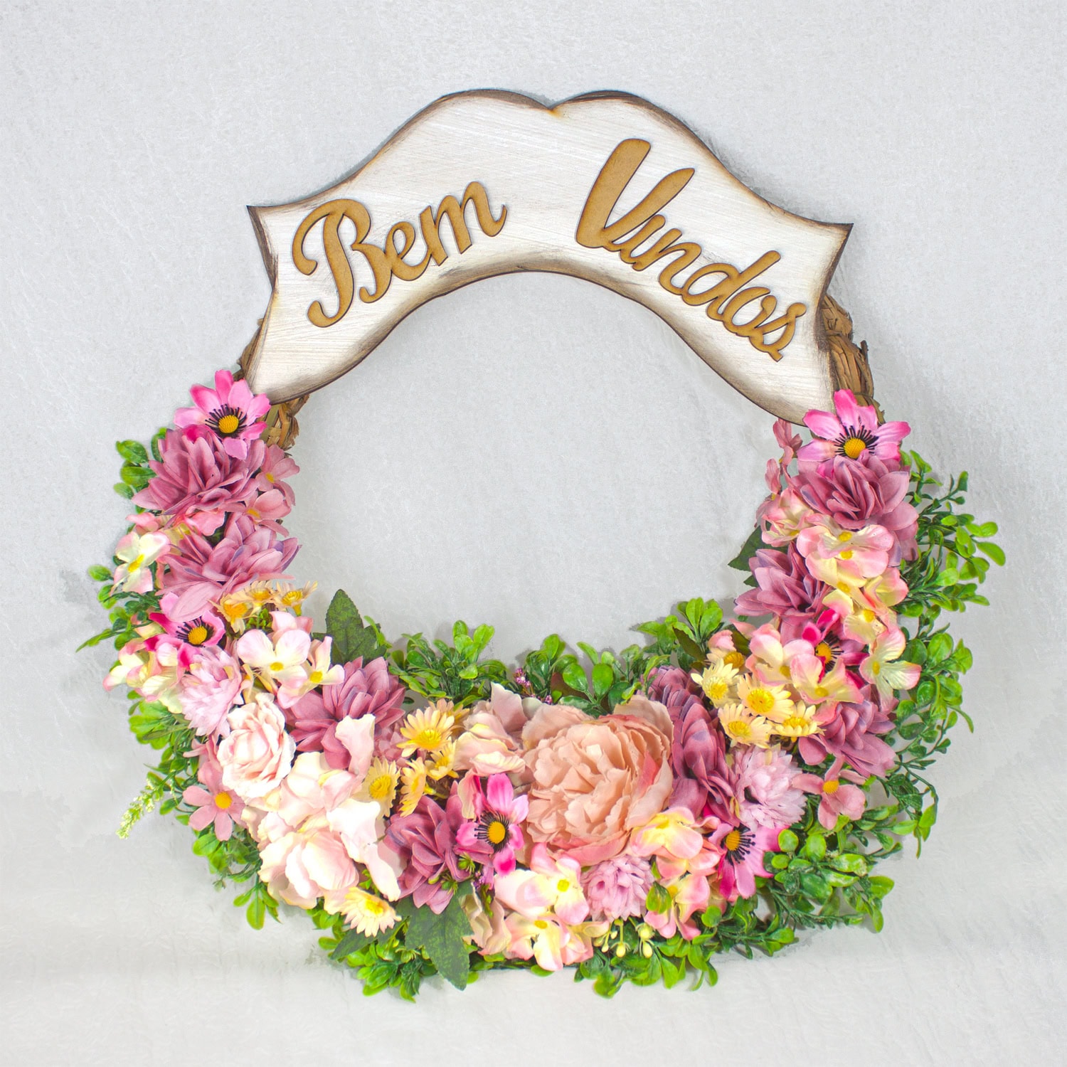 Benevindas em um arco decorativo de flores com placa de madeira com a mensagem "Bem Vindos".
